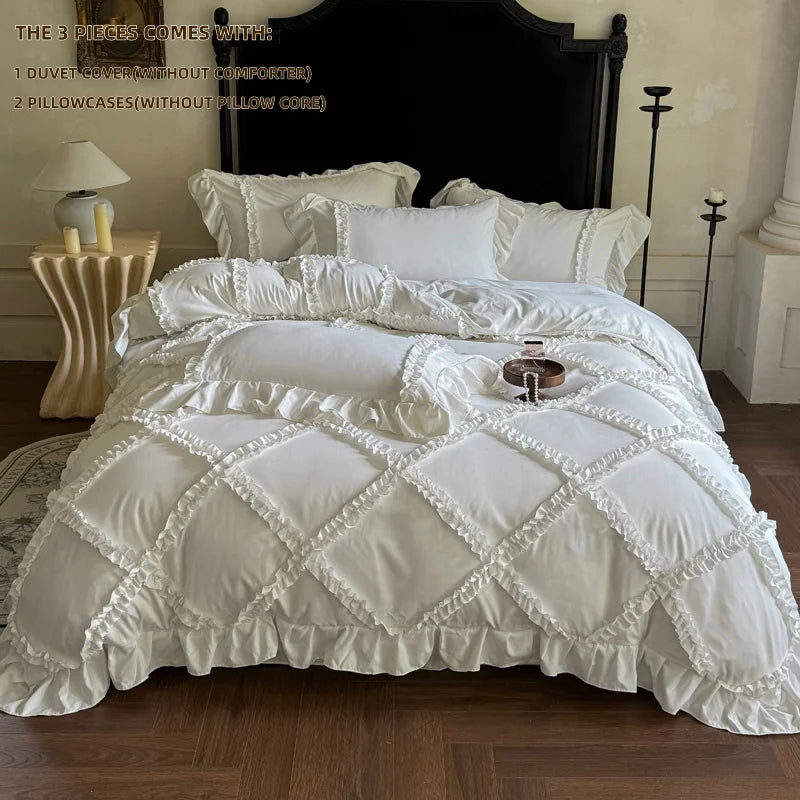 A white ruffled duvet cover set with matching pillowcases displayed on a bed against a dark wooden headboard.