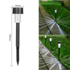 A black solar powered garden lantern light mounted on a stake, illuminating a pathway with light patterns.