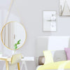 A bedroom setting featuring a white headboard, yellow bedding, and a gold-framed mirror above a light wood desk.