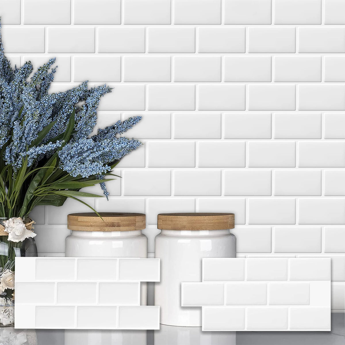 White subway tiles with glass jars and blue flowers displayed against a white brick wall background