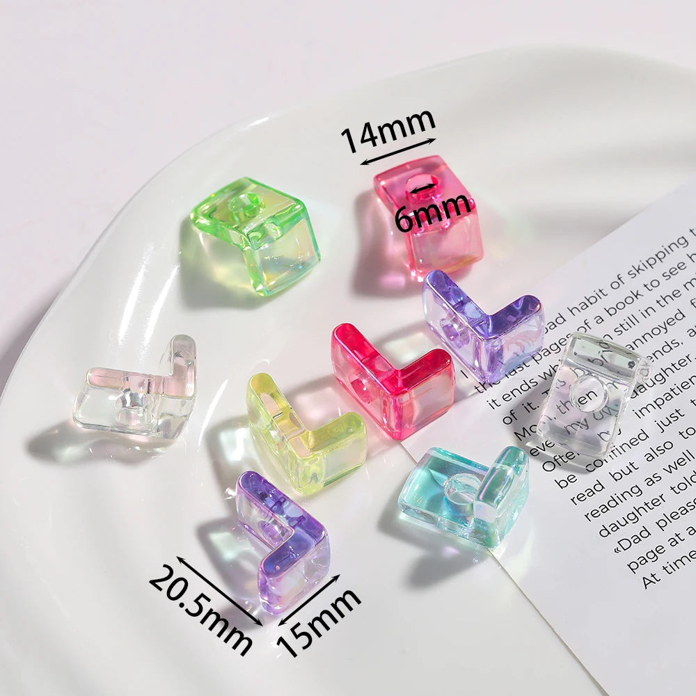 A collection of clear and colored acrylic alphabet beads displayed on a white plate.