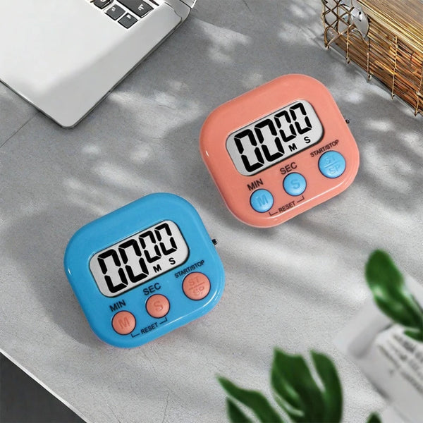 Dos temporizadores digitales de cocina magnéticos, uno rosa y otro azul, sobre una superficie clara.