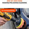 A hand is using a yellow electric polisher to apply a polishing pad to the black surface of a car.