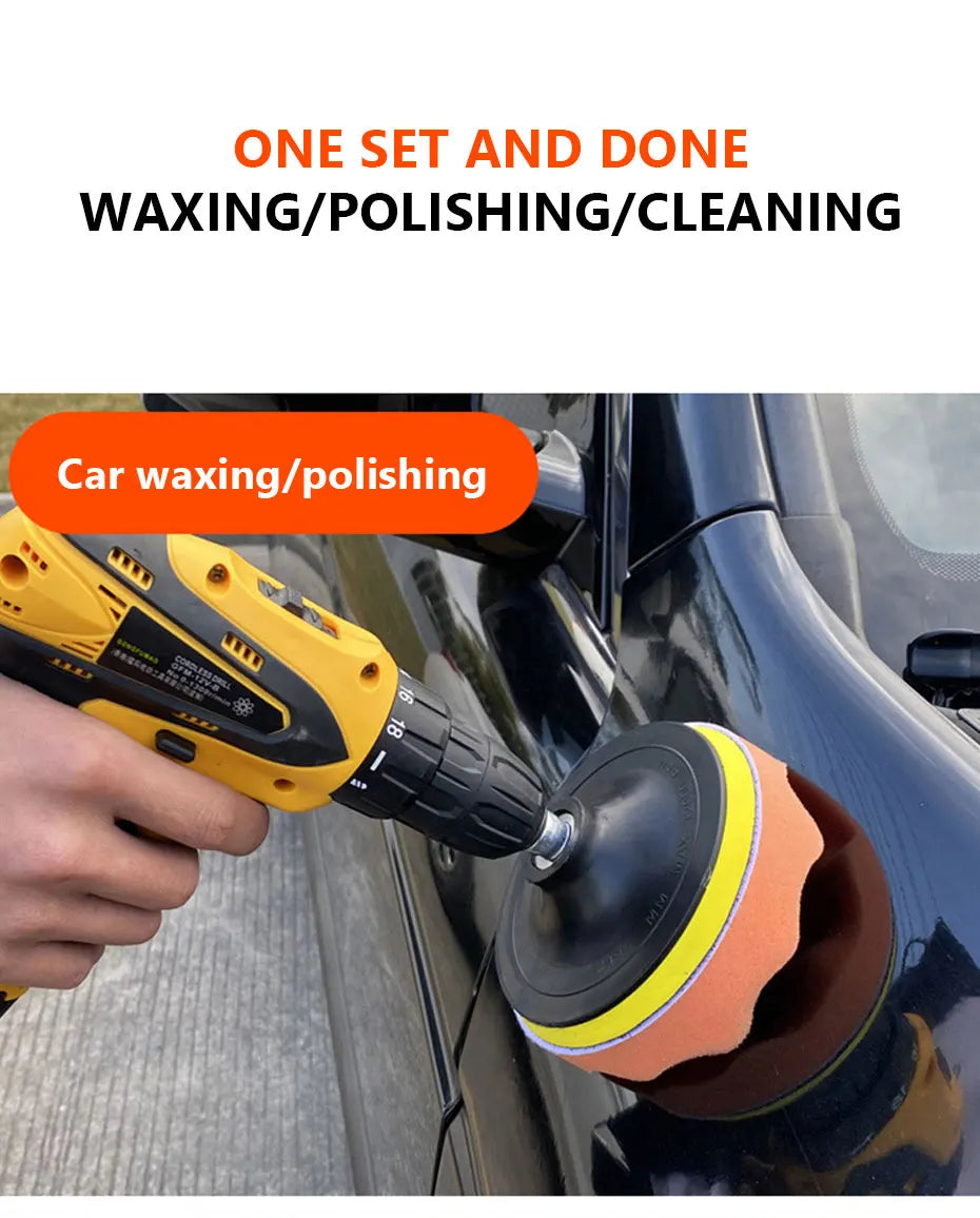 A hand is using a yellow electric polisher to apply a polishing pad to the black surface of a car.