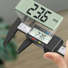 A hand holds a digital caliper displaying 236 mm, measuring an object.