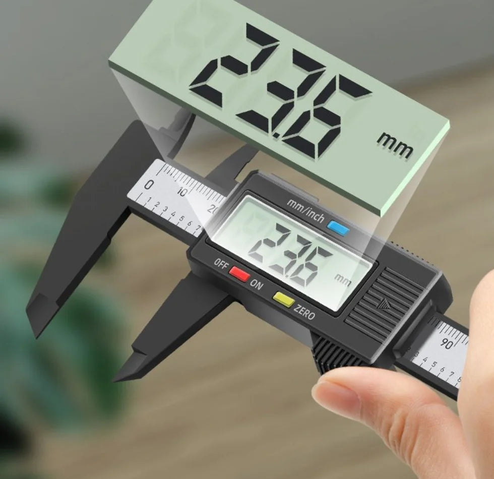 A hand holds a digital caliper displaying 236 mm, measuring an object.