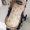 A beige baby stroller seat cushion with padded support and small bear-themed embroidery.