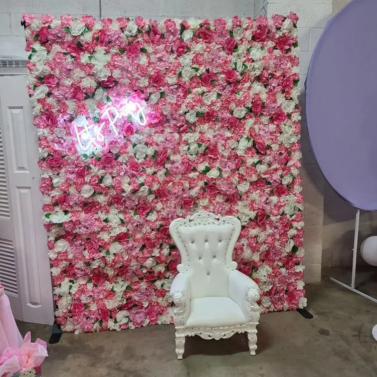 A pink silk rose flower wall panel decorated with white roses, featuring a white upholstered armchair in front.
