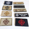 A collection of embroidered tactical patches featuring the Knights Templar symbol in various colors and styles.
