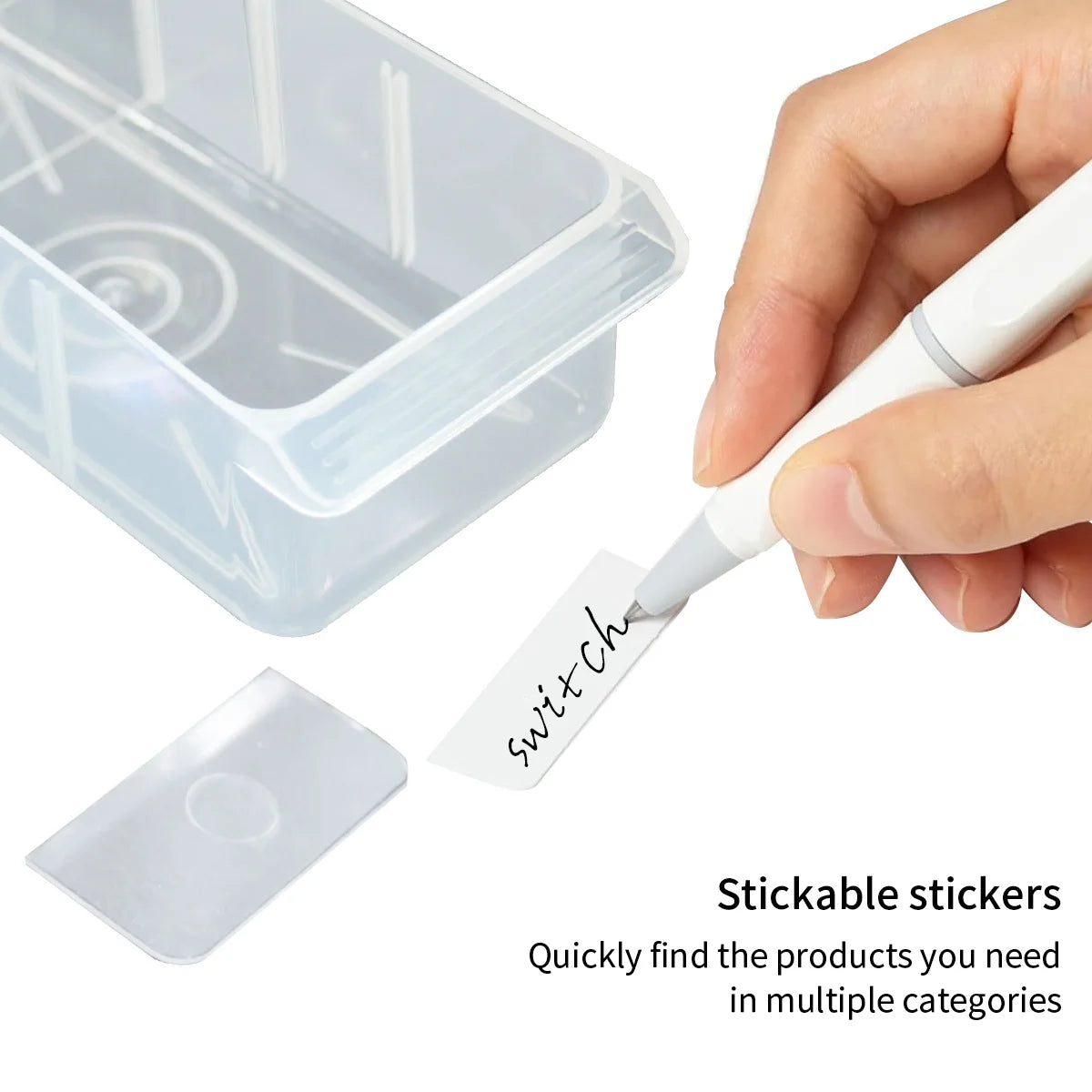 A hand is holding a white stickable sticker and placing it into a clear plastic organizer box.