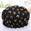 Black reusable elastic shower cap adorned with gold butterfly patterns