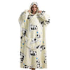 A woman wearing a cream-colored oversized wearable blanket hoodie with a panda print and a hood.