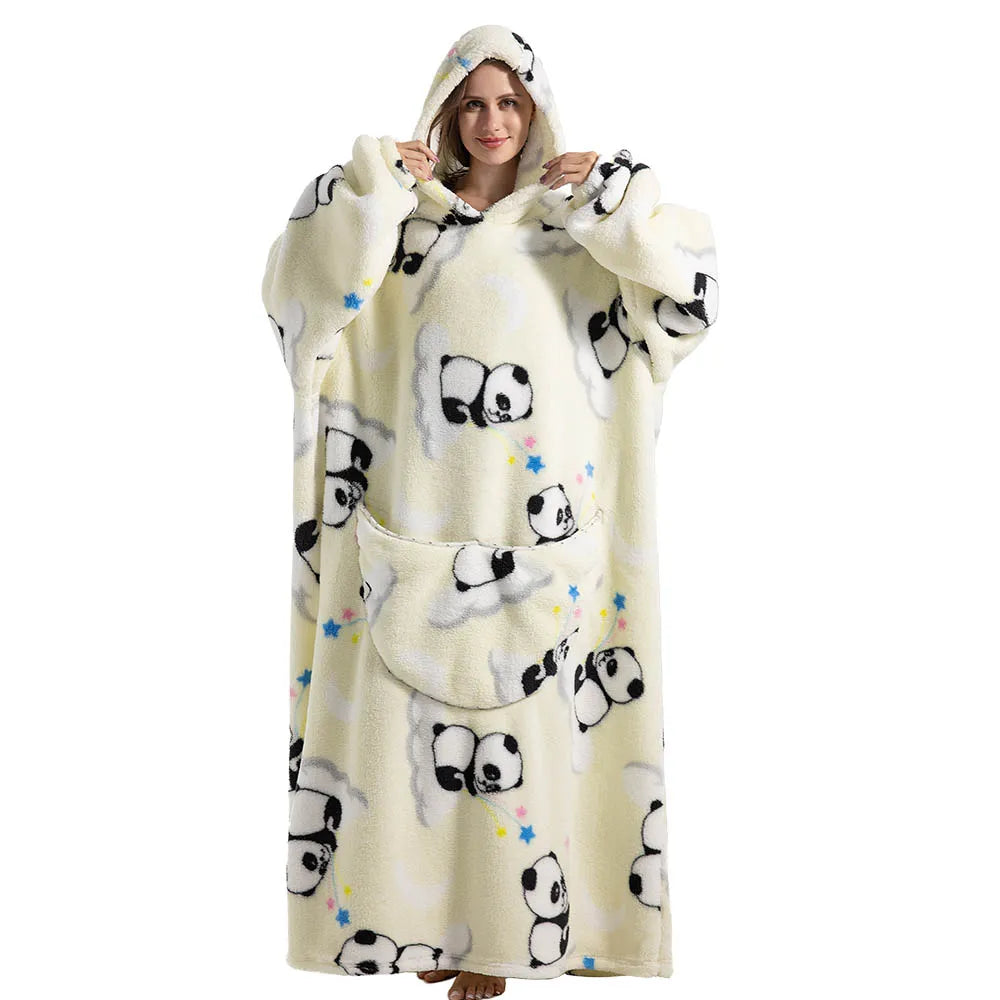 A woman wearing a cream-colored oversized wearable blanket hoodie with a panda print and a hood.