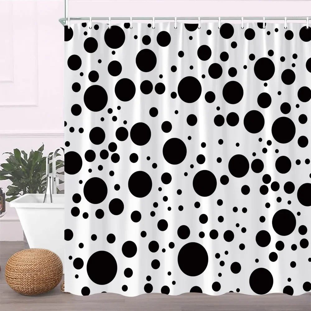 Black and white polka dot fabric shower curtain with hooks hanging in a bathroom