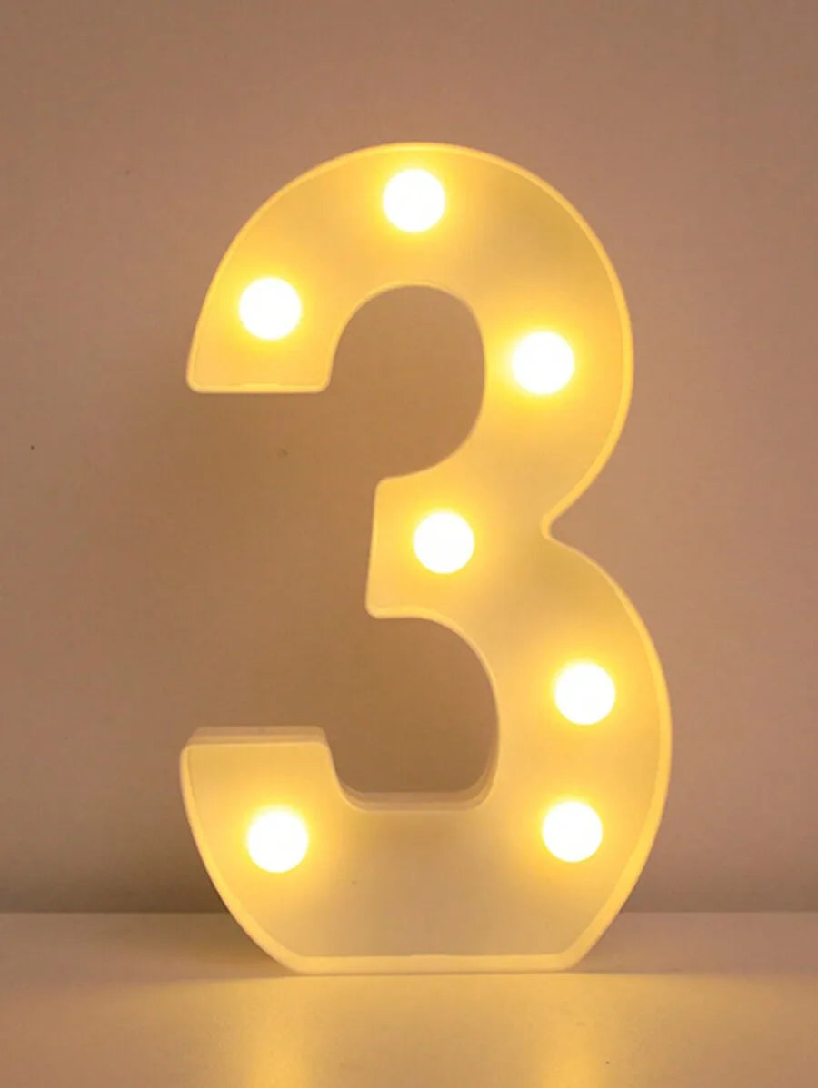 A glowing, illuminated LED letter '3' night light with decorative round lights.