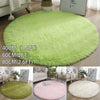 A collection of round, ultra-soft, shaggy rugs in various shades of green and pink on a wooden floor.