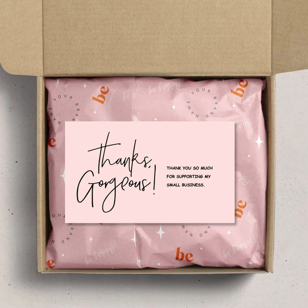 A box containing a pink tissue paper product with a thank you message inside