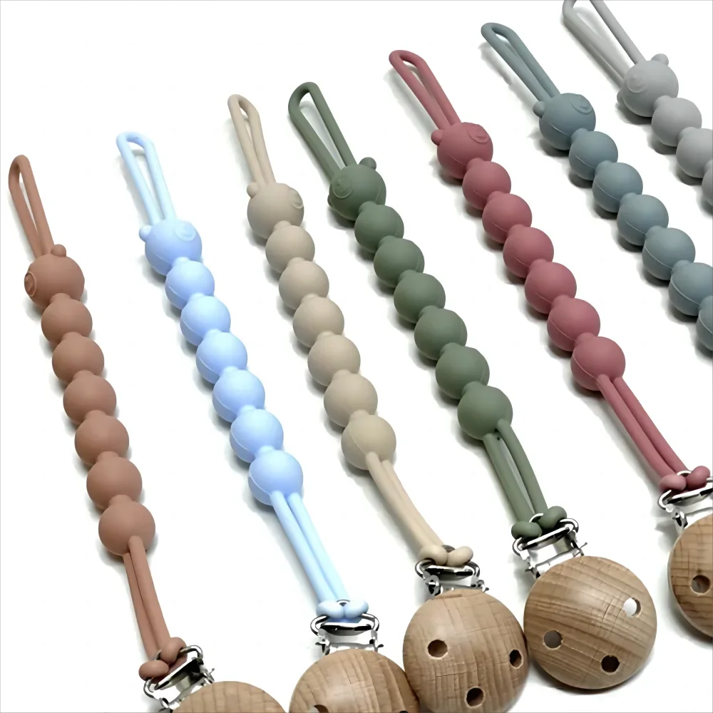 A set of food-grade silicone pacifier clips with anti-lost chains in various pastel colors like pink, green, and blue.