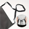 A black PU leather waterproof apron with adjustable straps shown next to a person wearing it.