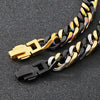 A close-up of a chunky stainless steel Cuban chain bracelet featuring black and gold links.