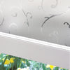 Close-up of frosted stripe privacy window film applied to a white window frame, showing decorative swirling patterns.