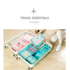A light blue and pink packing cube set with various storage compartments is shown inside a white rolling suitcase.