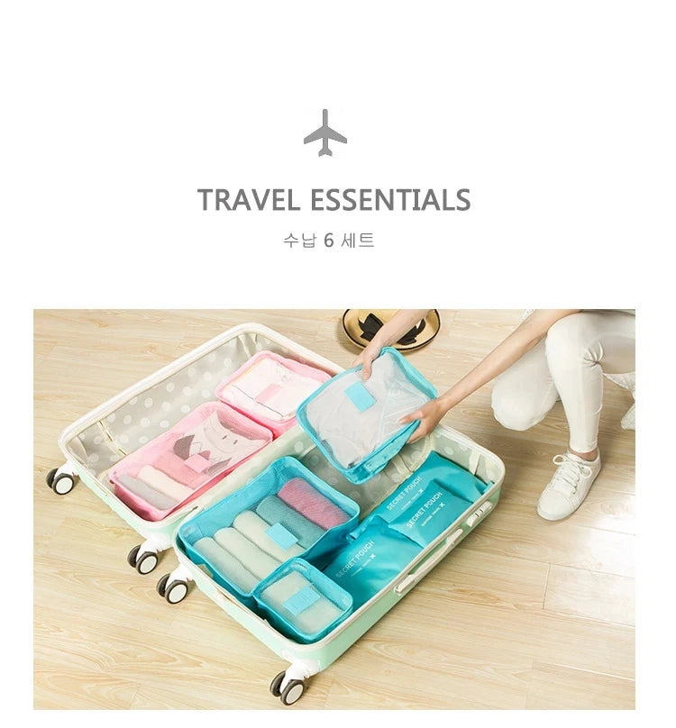 A light blue and pink packing cube set with various storage compartments is shown inside a white rolling suitcase.