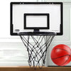 A portable mini basketball hoop set with a black backboard and net is mounted on a wooden surface.