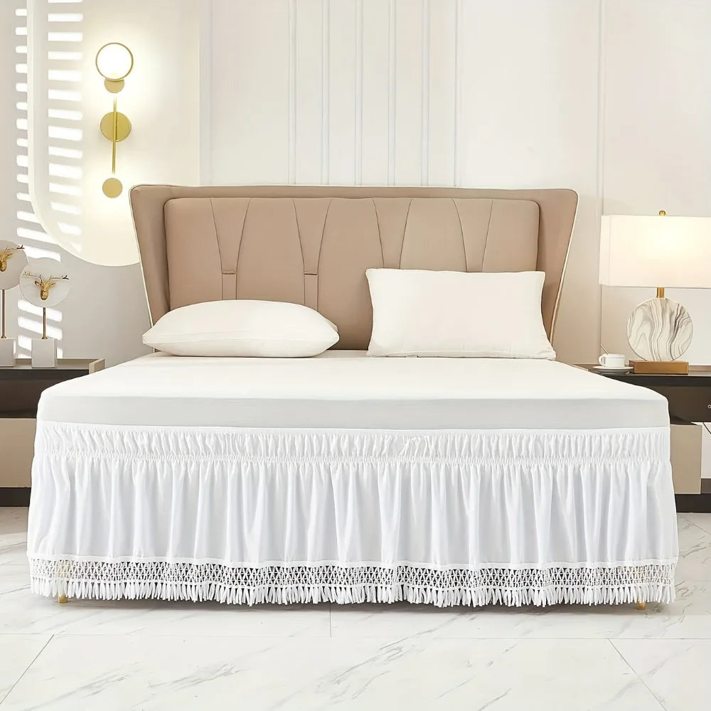 A bed featuring a beige upholstered headboard, white bedding, and an elastic wrap-around ruffled skirt with lace trim.