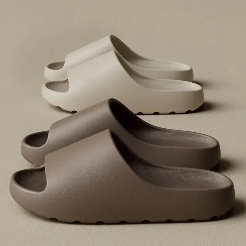 A pair of taupe-colored EVA slides for men and women are shown in a stacked arrangement.