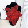 A vibrant red floral lace applique patch covered in sequins displayed on a black mannequin.