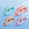 Three clear adhesive tape rollers in blue, pink, and purple shades shown at an angle