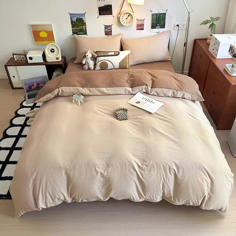 A beige ultra-soft washed cotton duvet cover set with four pillows and a matching duvet on a bed.