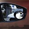 Close-up view of a black car mirror showing a white car and a reflection.