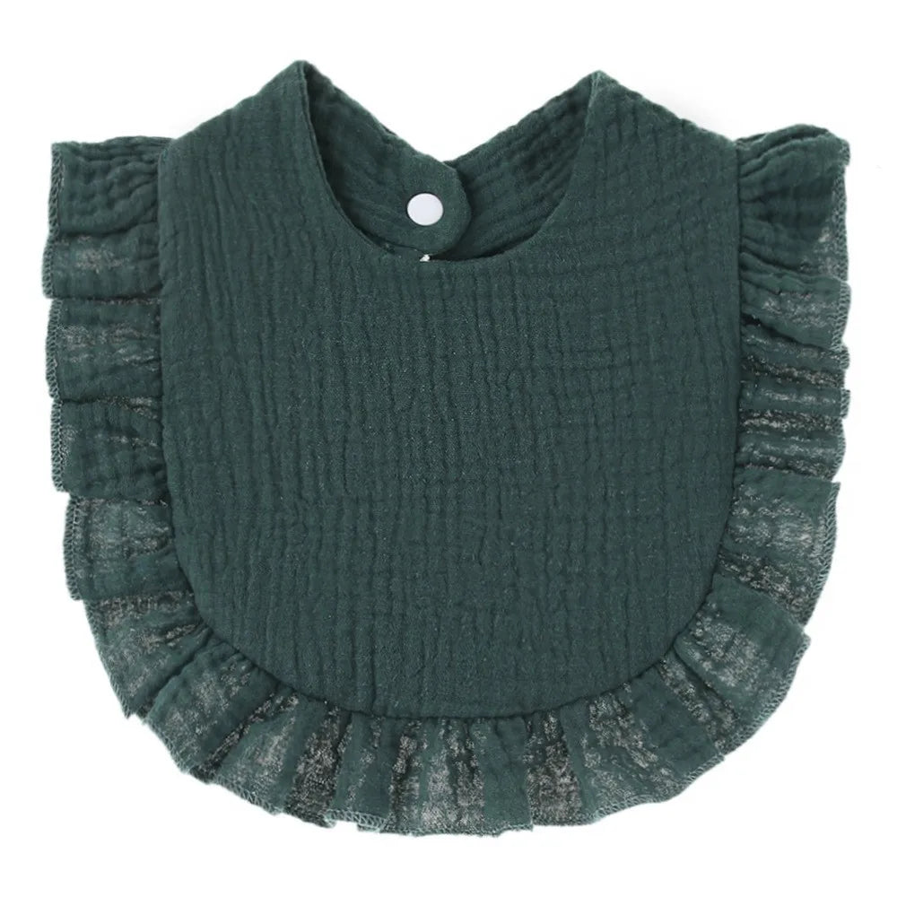 A dark teal knitted baby bib with ruffled edges and a small button closure.