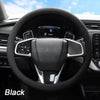 Black soft silicone steering wheel cover installed in a car interior.