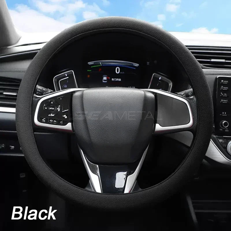 Black soft silicone steering wheel cover installed in a car interior.