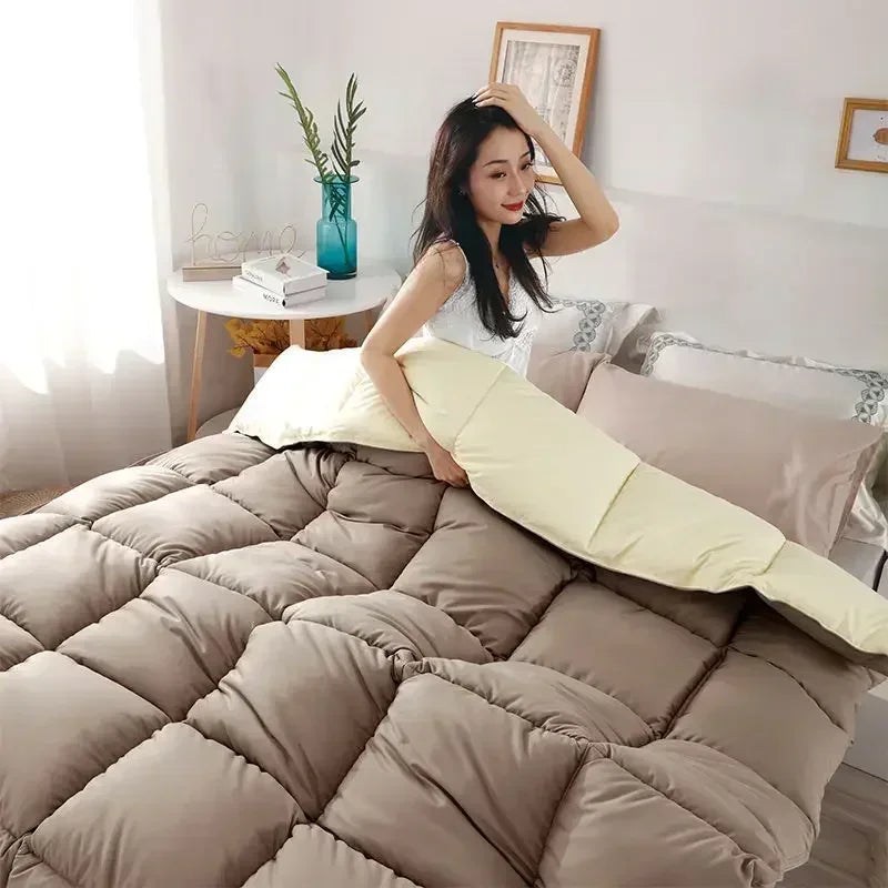 A woman is posing with a luxury white goose and duck down comforter on a bed.