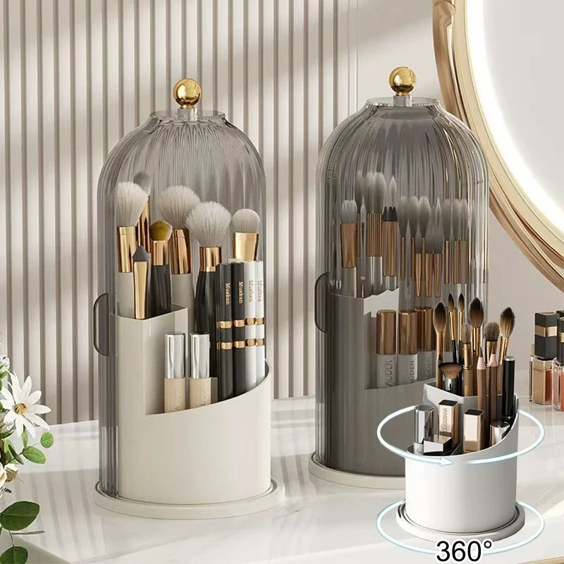 A clear glass rotating makeup brush holder with a dustproof lid displaying various makeup brushes and tools.
