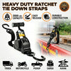 Black heavy duty ratchet tie down straps with various applications shown on a wooden surface.