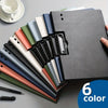 A stack of six colored A4 clip folders with protective covers displayed on a gray surface.