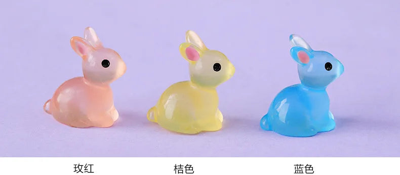 A set of three cute resin miniature bunny figurines in pink, yellow, and blue.