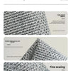 Close-up of a gray fish plaid woven fabric showing fine stitching and texture details.