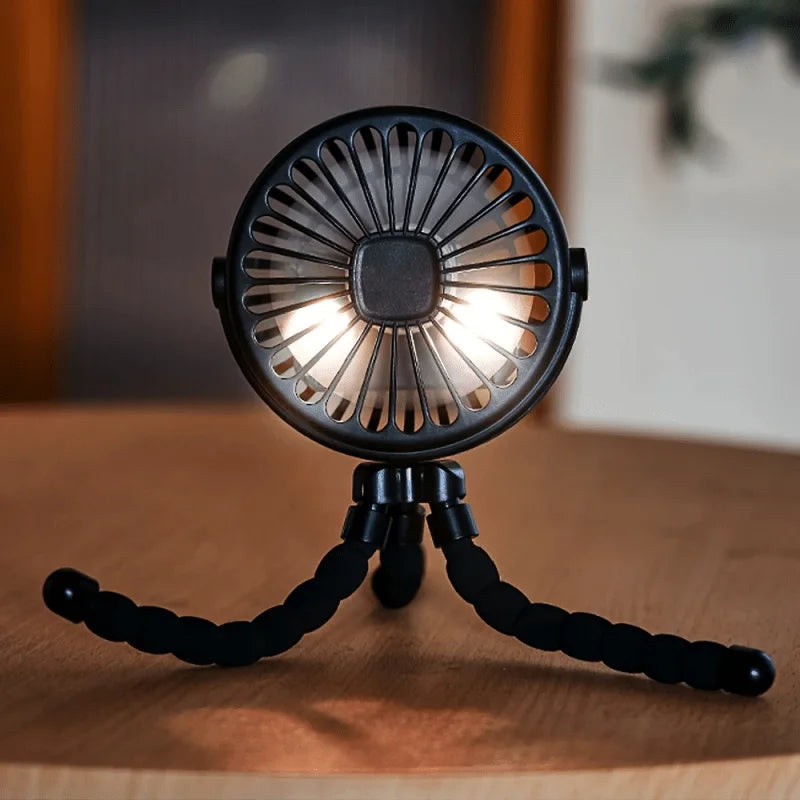 A black flexible octopus USB fan with a tripod stand is shown on a wooden surface.