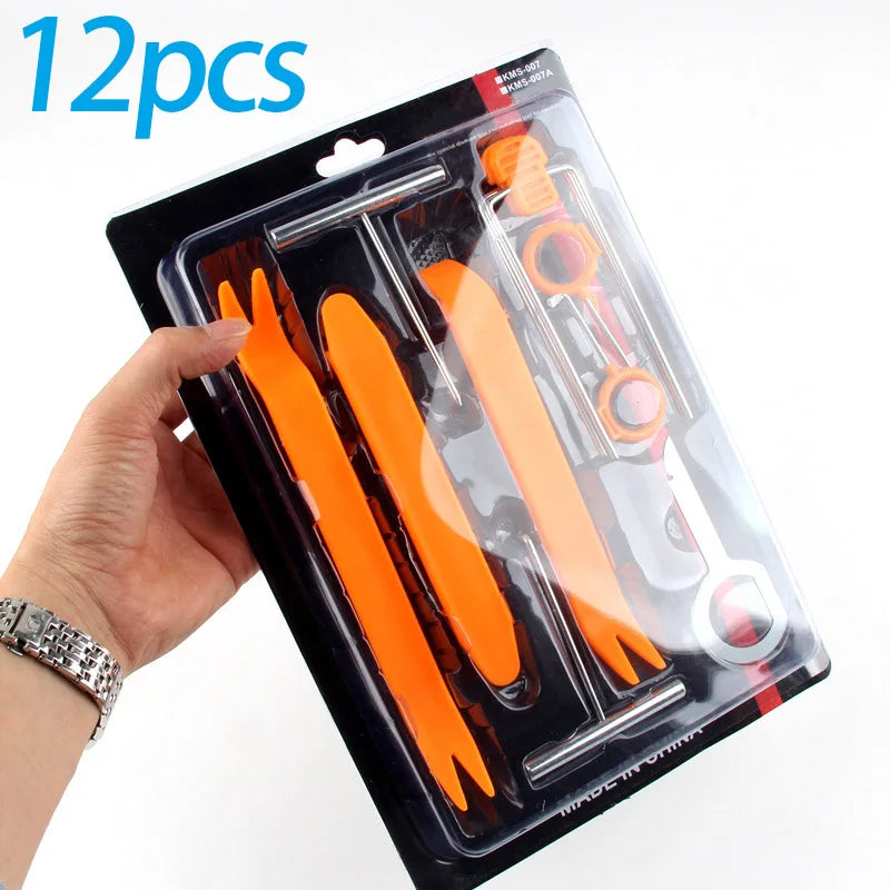 A hand holds a package of 12 pieces of orange car trim removal tools in a clear plastic storage pouch.