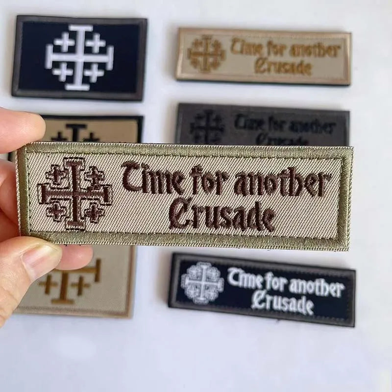 A collection of embroidered tactical patches featuring the text Time for another Crusade on various colored backgrounds.