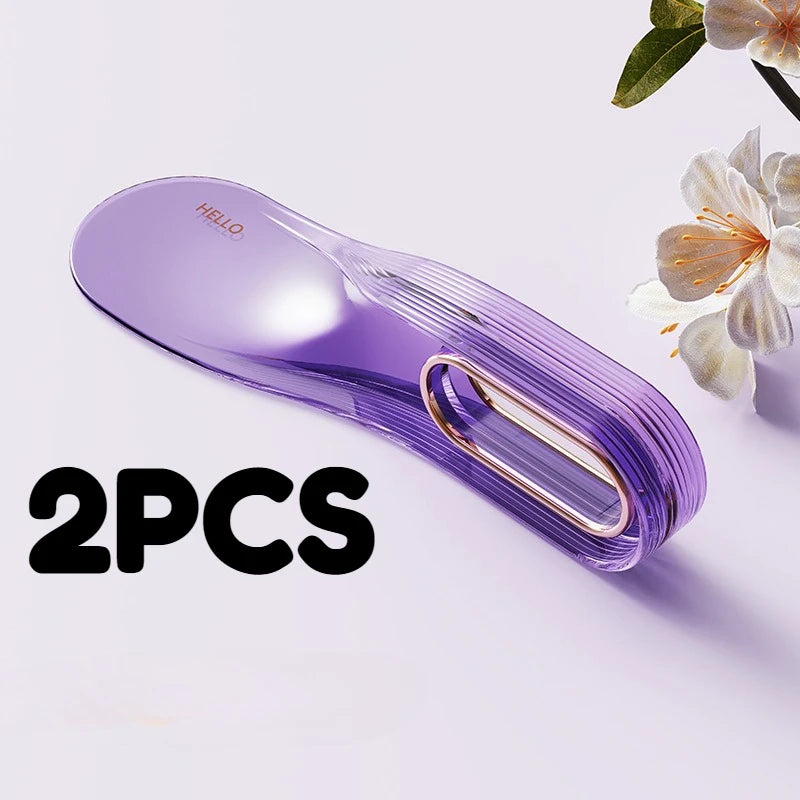 Two purple mattress lifter wedge tools are shown on a white surface next to a flower.