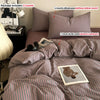 A striped mauve duvet cover set with three pillowcases and a comforter shown on a bed.
