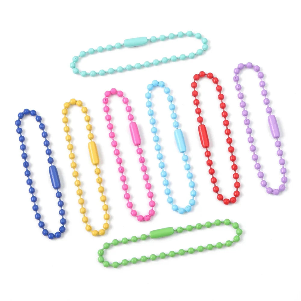 Eine Sammlung farbenfroher, langlebiger Metallkugelketten in verschiedenen Farben wie blau, pink, gelb und rot.