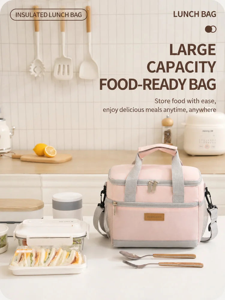 A pink insulated lunch bag is shown with utensils and food containers on a white table.